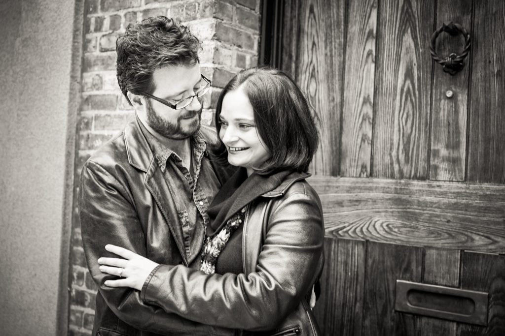 Black and white photo of couple in front of wooden door