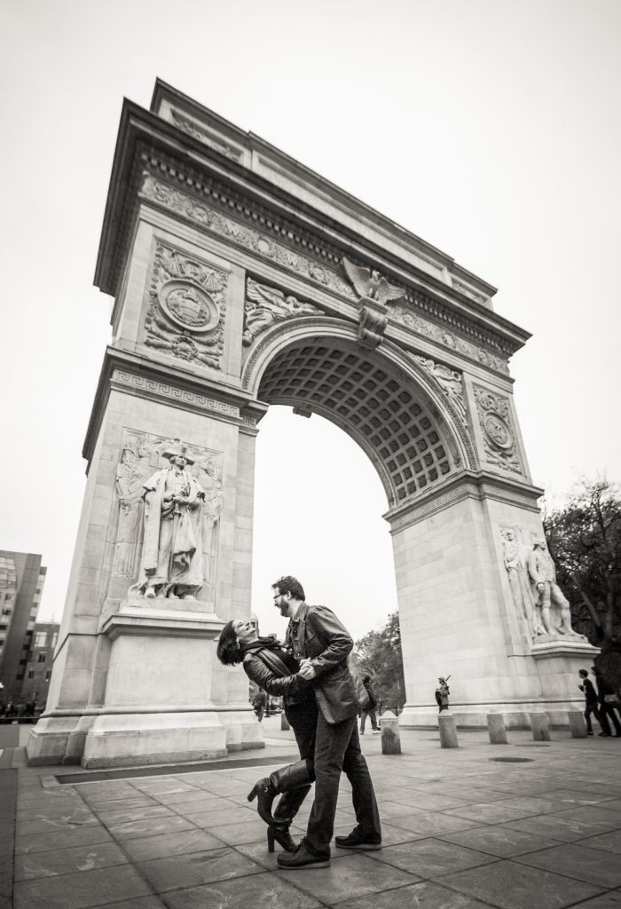 Black and white photo of couple dancing in front of Washington Square Arch
