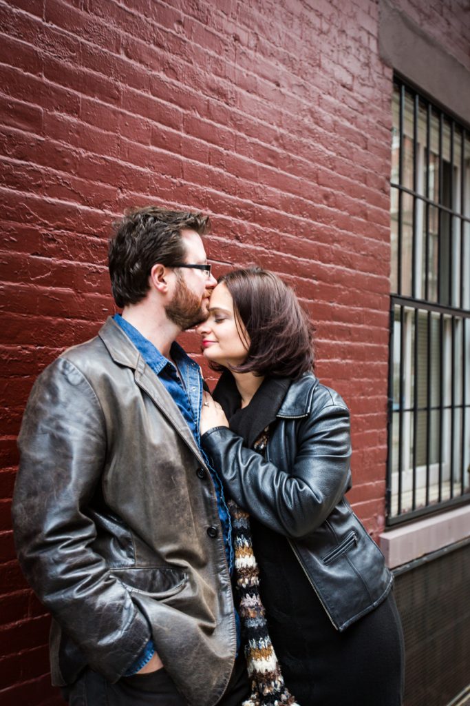Couple kissing against brick wall in Greenwich Village