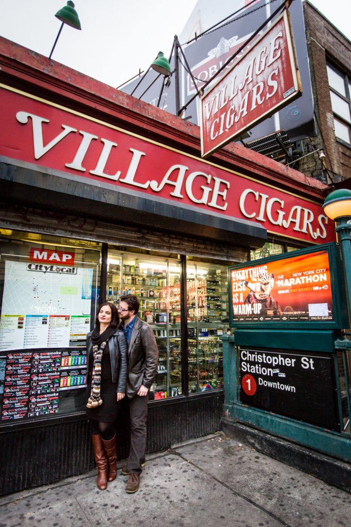 Couple standing under Village Cigars sign in Greenwich Village