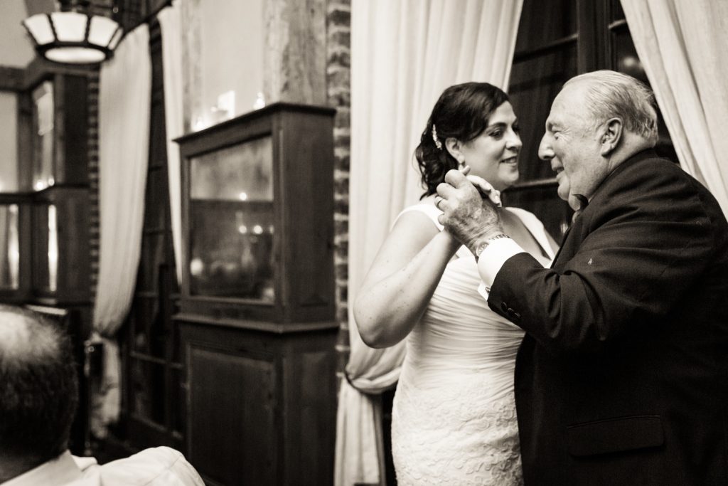 Bride dancing with father in black and white