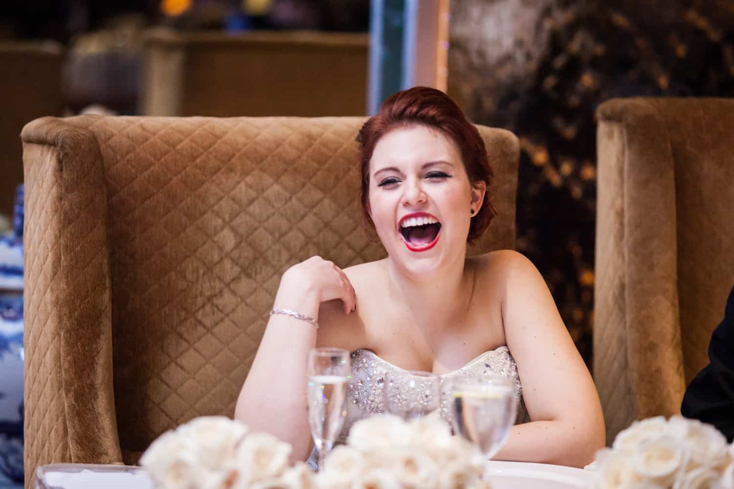 Bride sitting at table and laughing