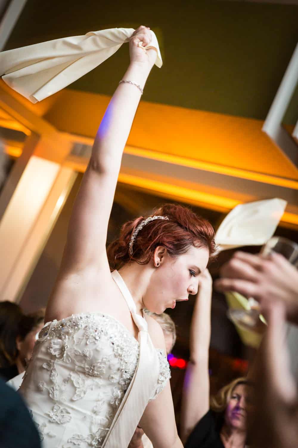 Nicotra's Ballroom wedding photos of bride wearing tie waving napkin in air