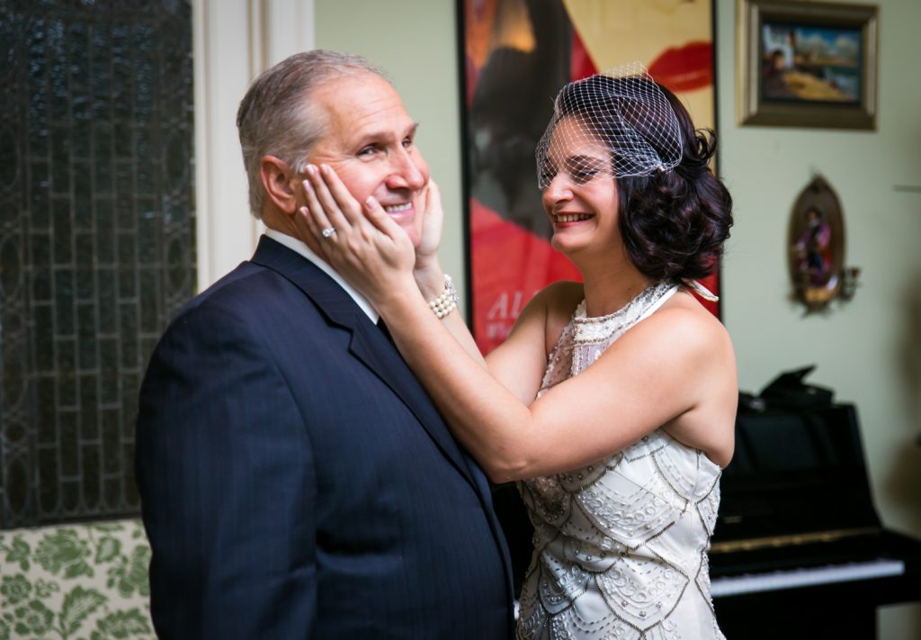 Bride grabbing cheeks of her father