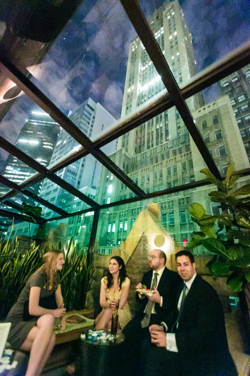 Guests sitting in glass-enclosed terrace area in Library Hotel