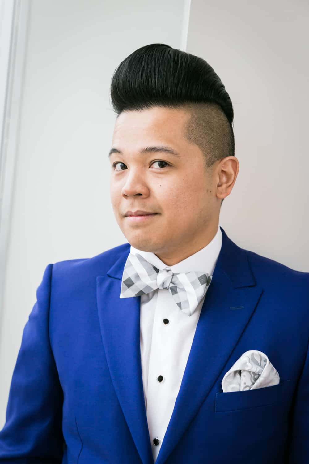 Portrait of groom in blue suit and bow tie
