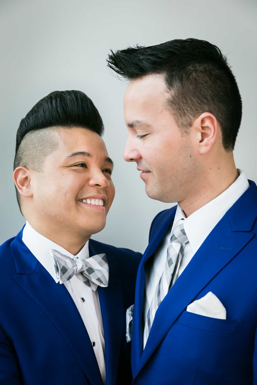 Two grooms in blue suits looking at each other