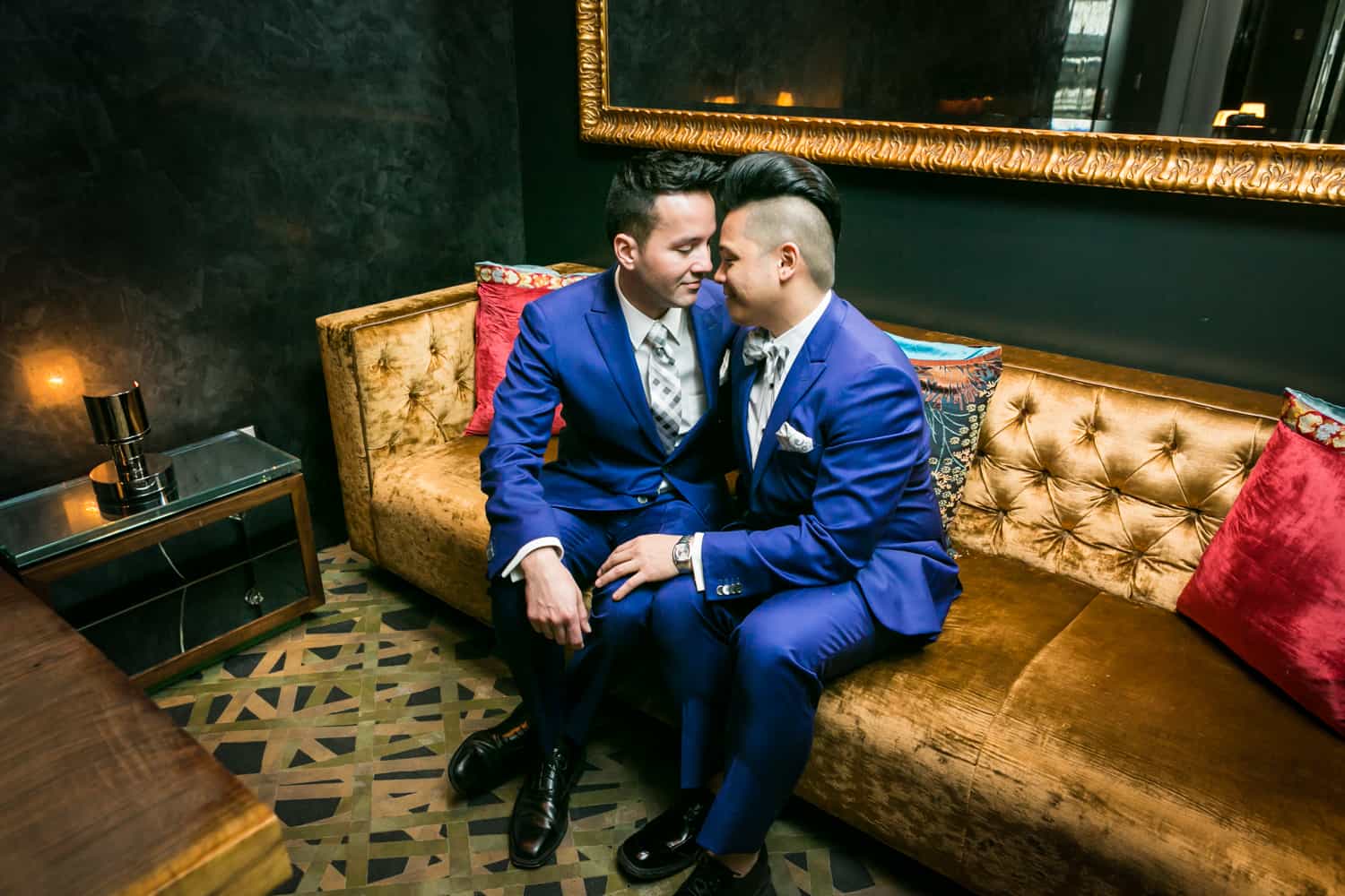 Two grooms cuddling on a couch