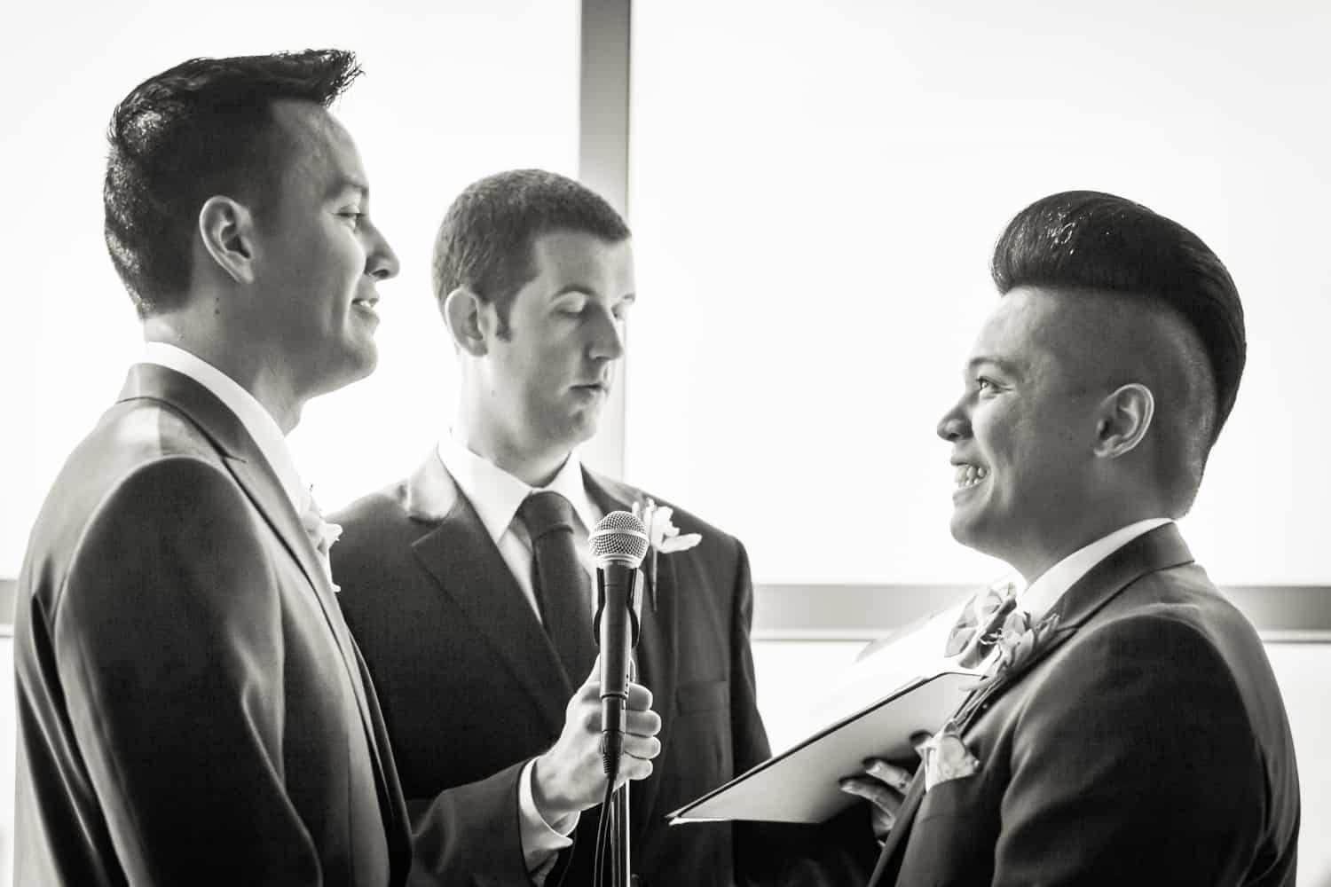 Black and white photo of two grooms exchanging vows