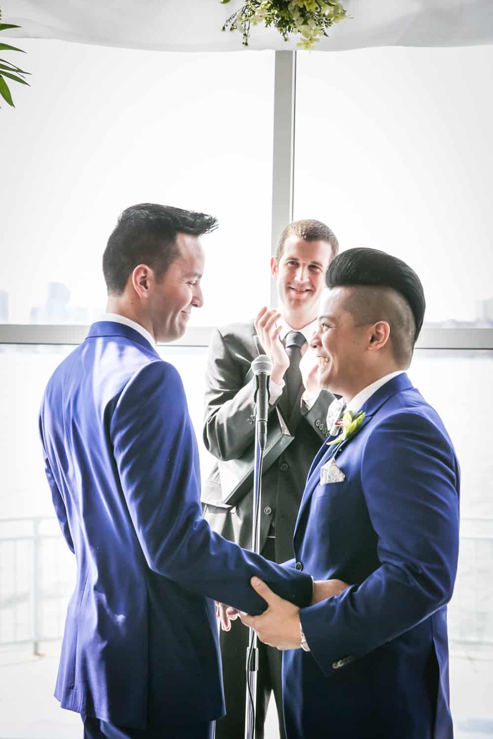 Two grooms during ceremony at a Lighthouse at Chelsea Piers wedding