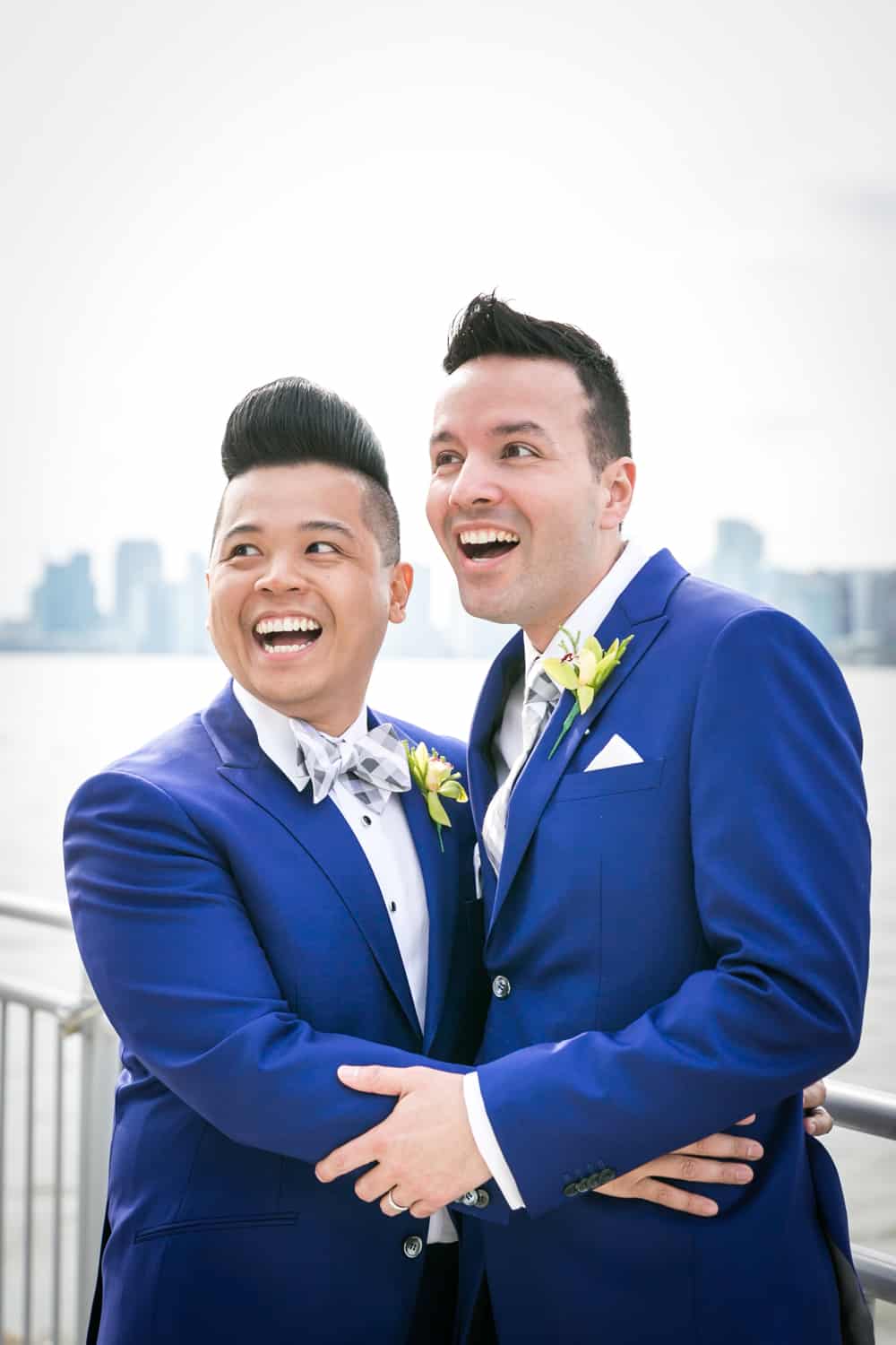 Two grooms hugging by Hudson River waterfront