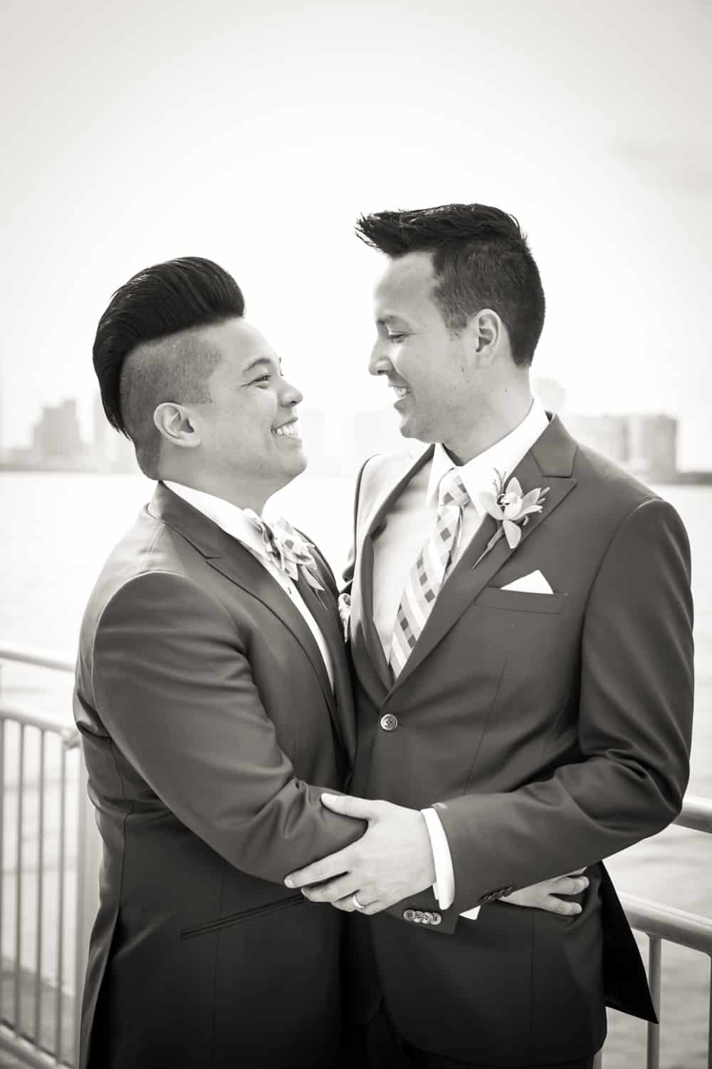 Black and white photo of two grooms beside Hudson River waterfront