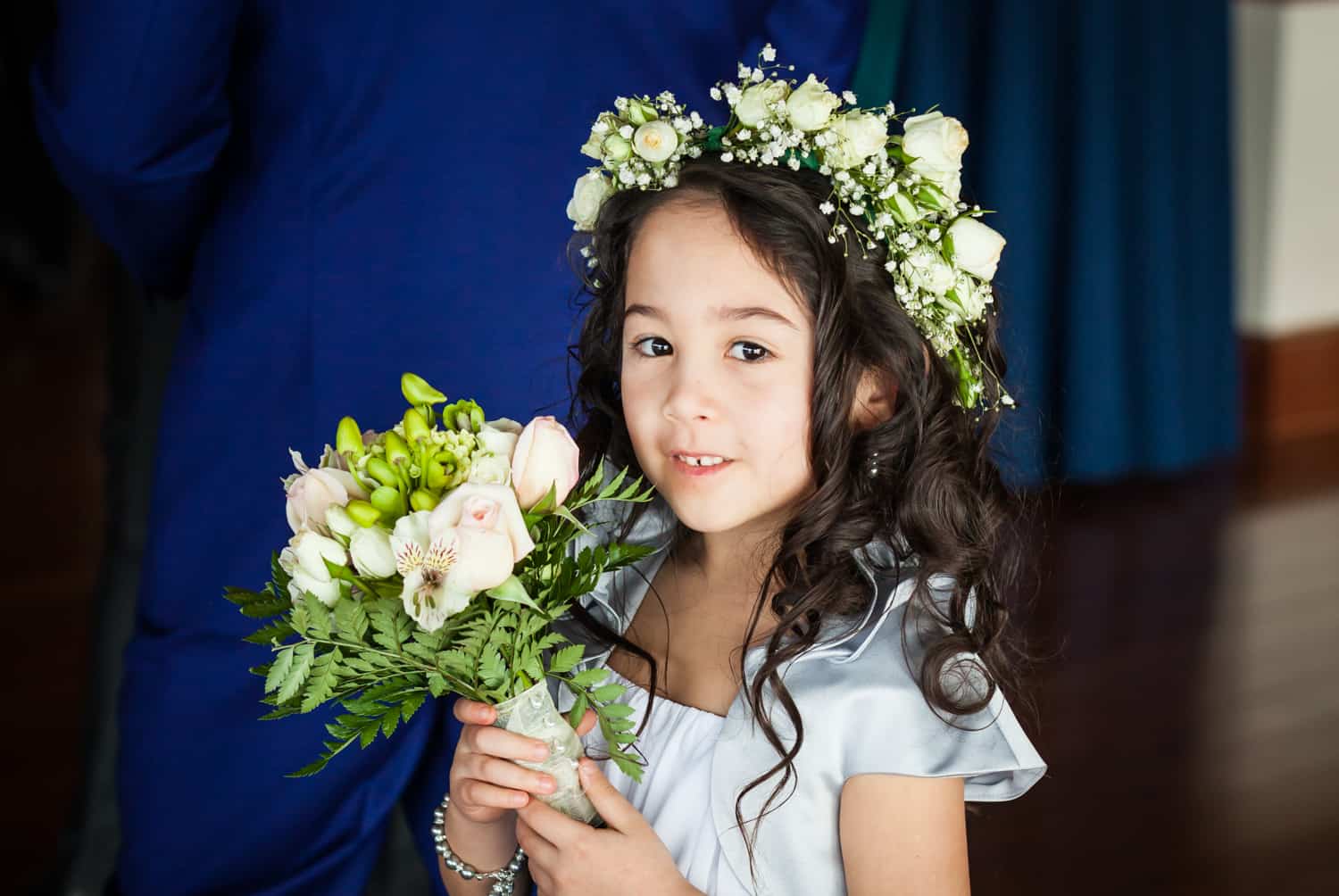 Little flower girl holding bouquet and wearing flower crown