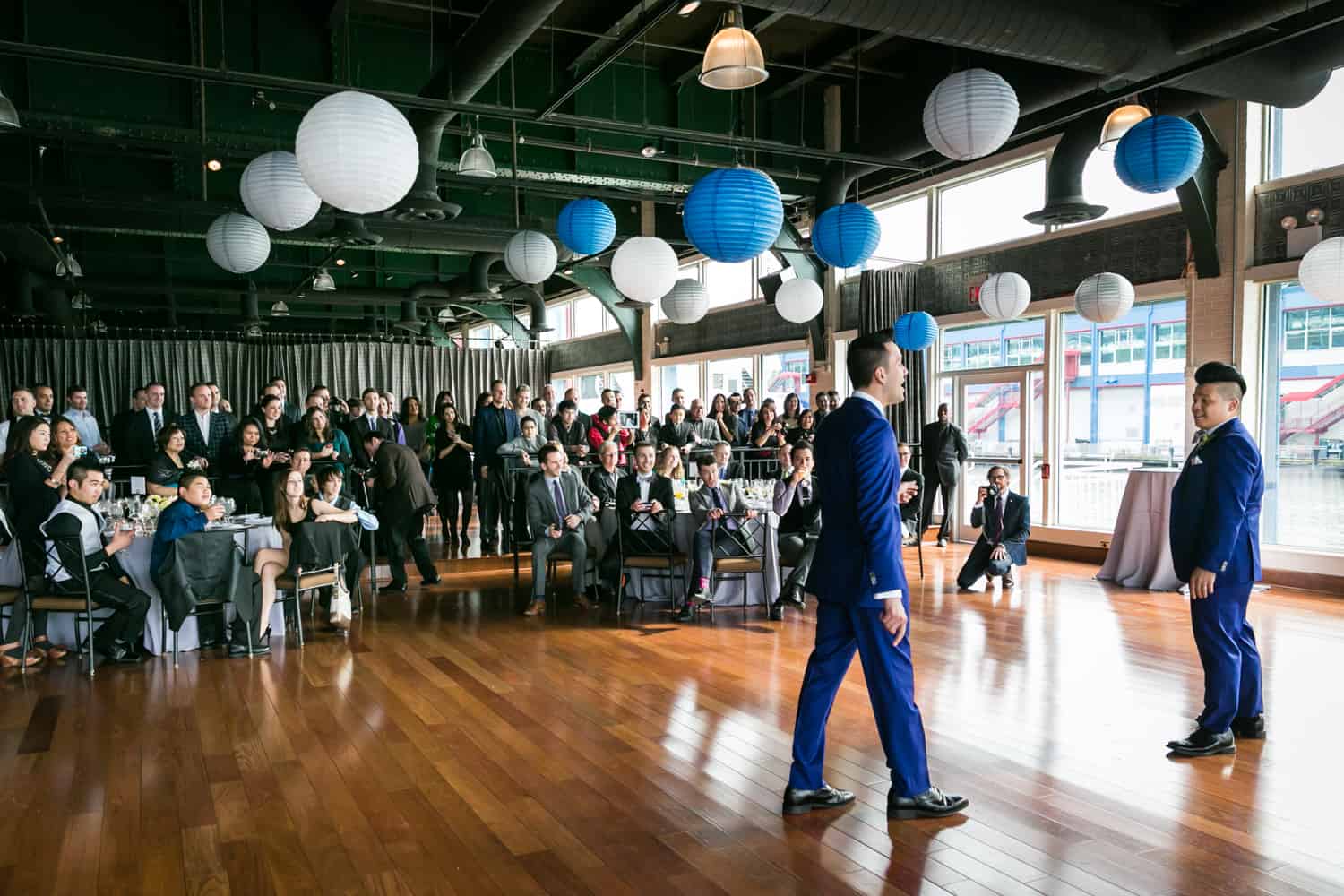 Two grooms dancing in front of guests at a Lighthouse at Chelsea Piers wedding