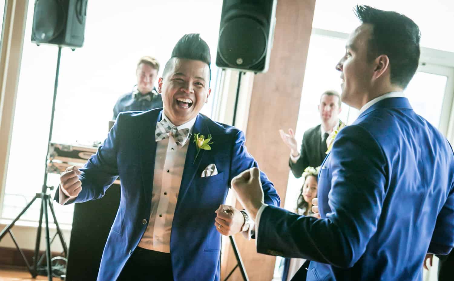Two grooms dancing in front of guests at a Lighthouse at Chelsea Piers wedding