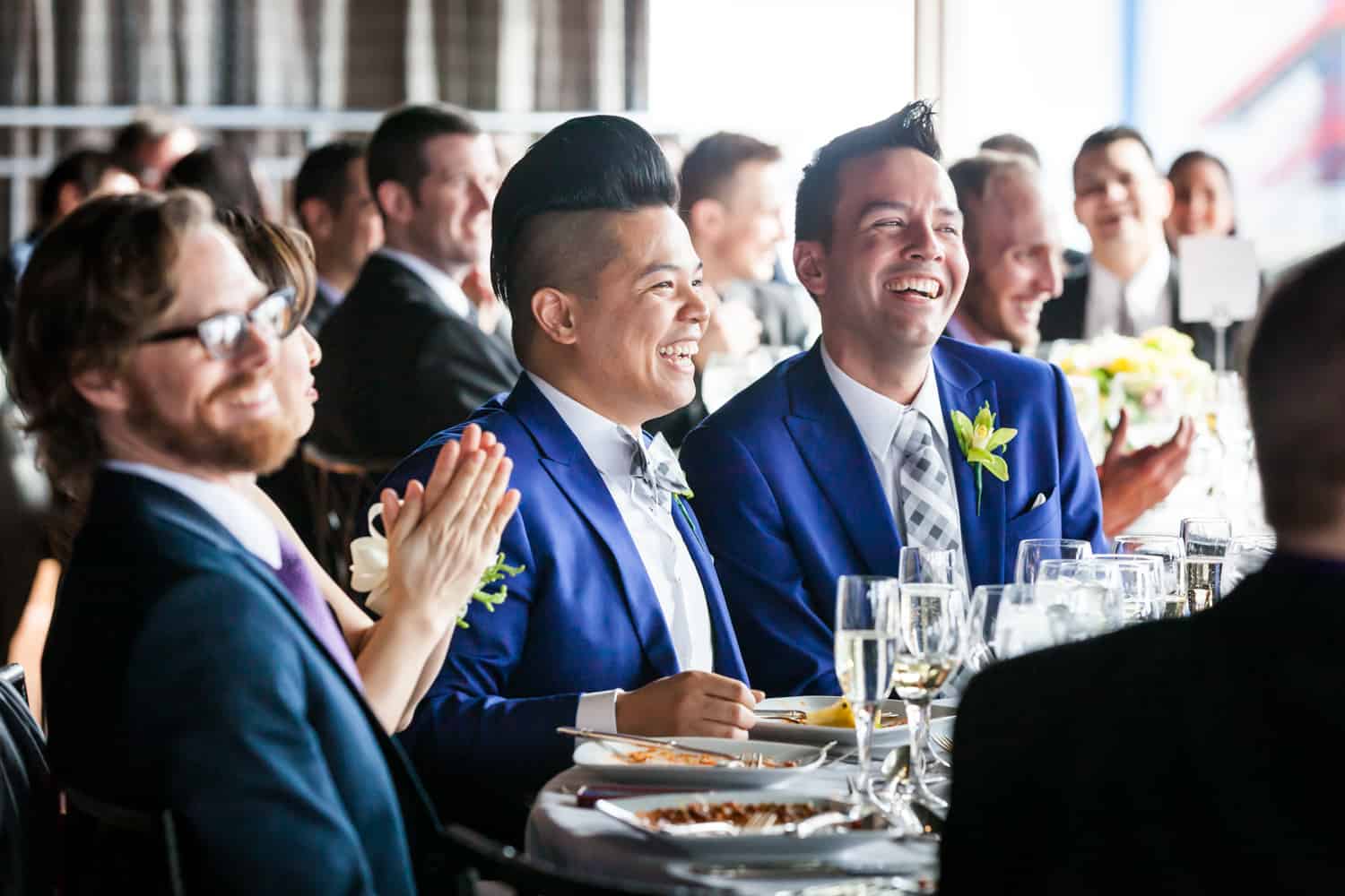 Grooms and guests watching speeches at a Lighthouse at Chelsea Piers wedding