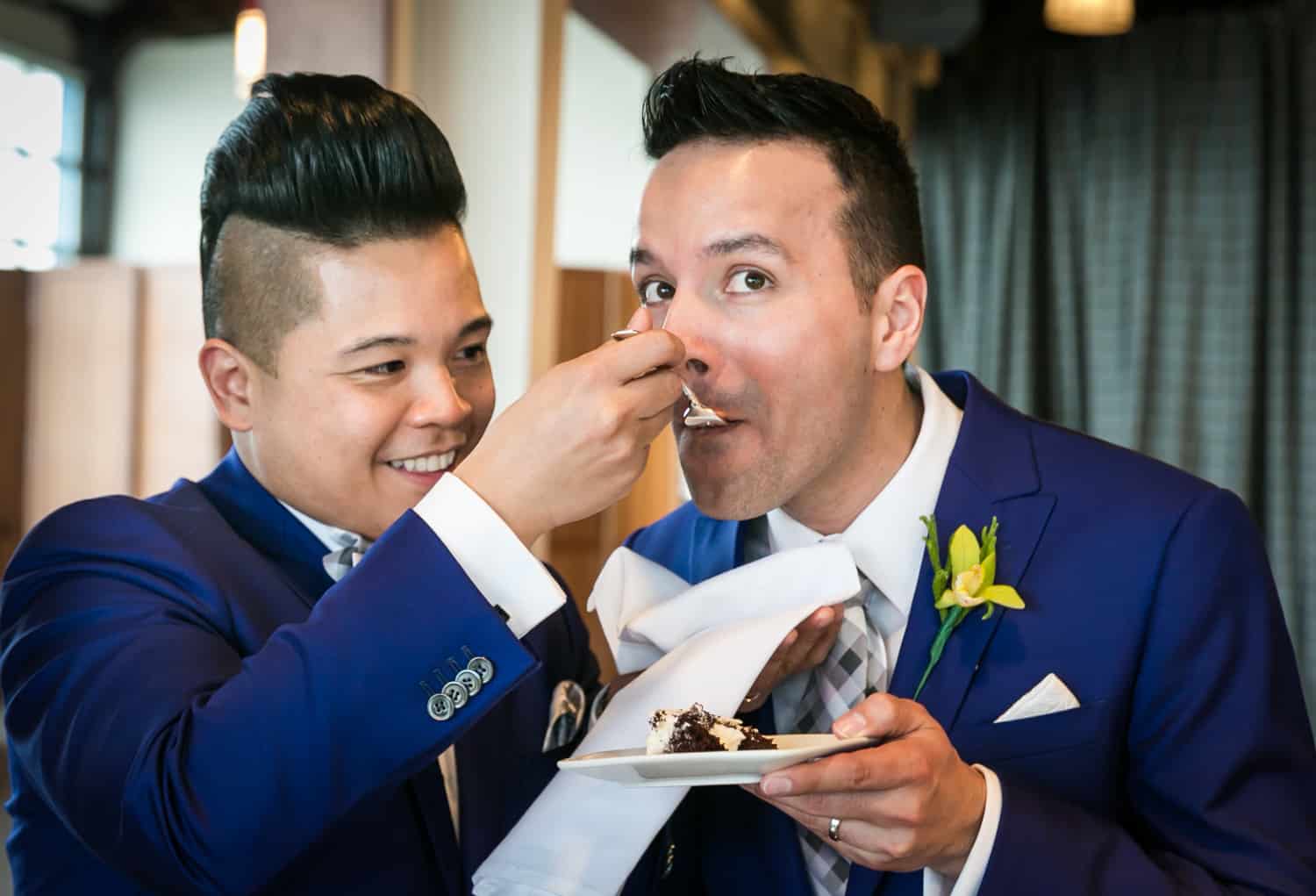 Groom feeding another groom cake at a Lighthouse at Chelsea Piers wedding