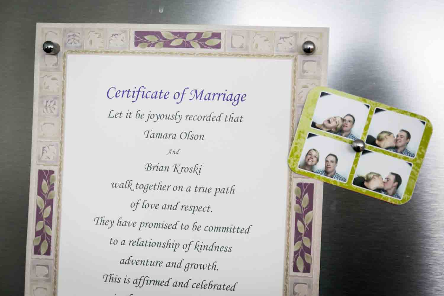 Wedding invitation sign on refrigerator next to photobooth photos of bride and groom