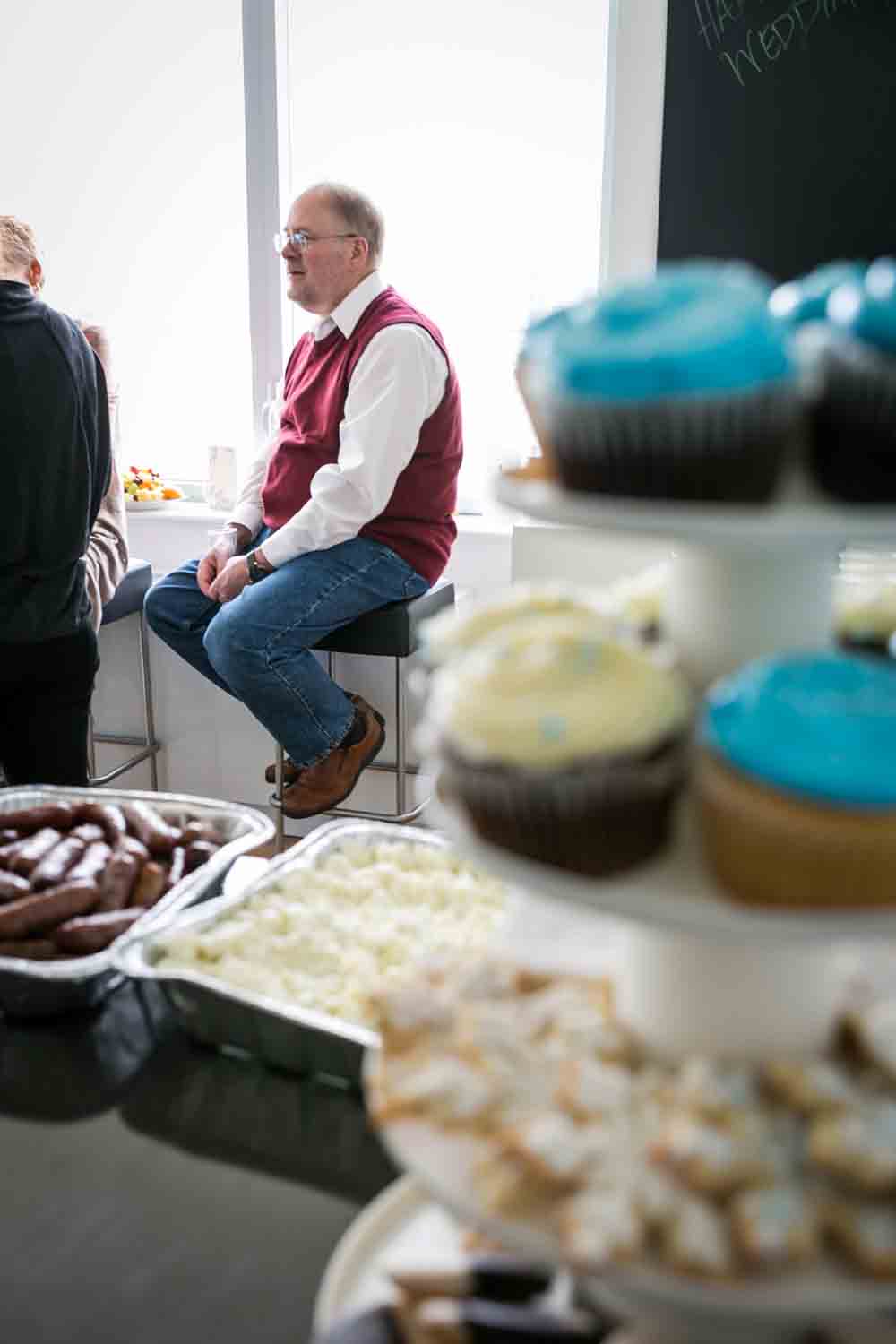 View through cupcakes of man sitting by window