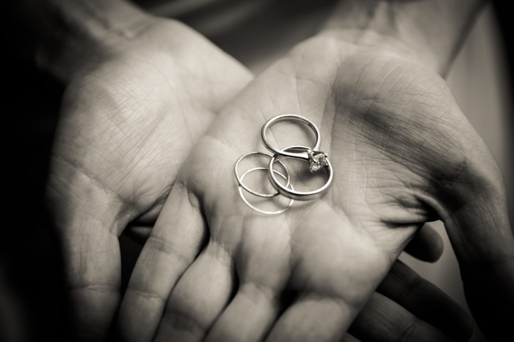 Black and white photo of wedding rings in hands
