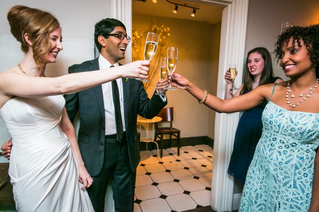 Bride and groom toasting champagne glasses with guests