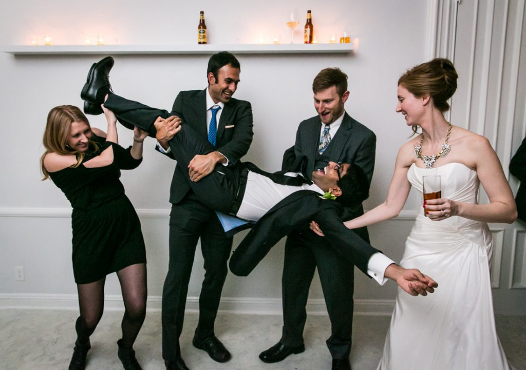 Guests holding groom upside down at a Maison May Brownstone wedding