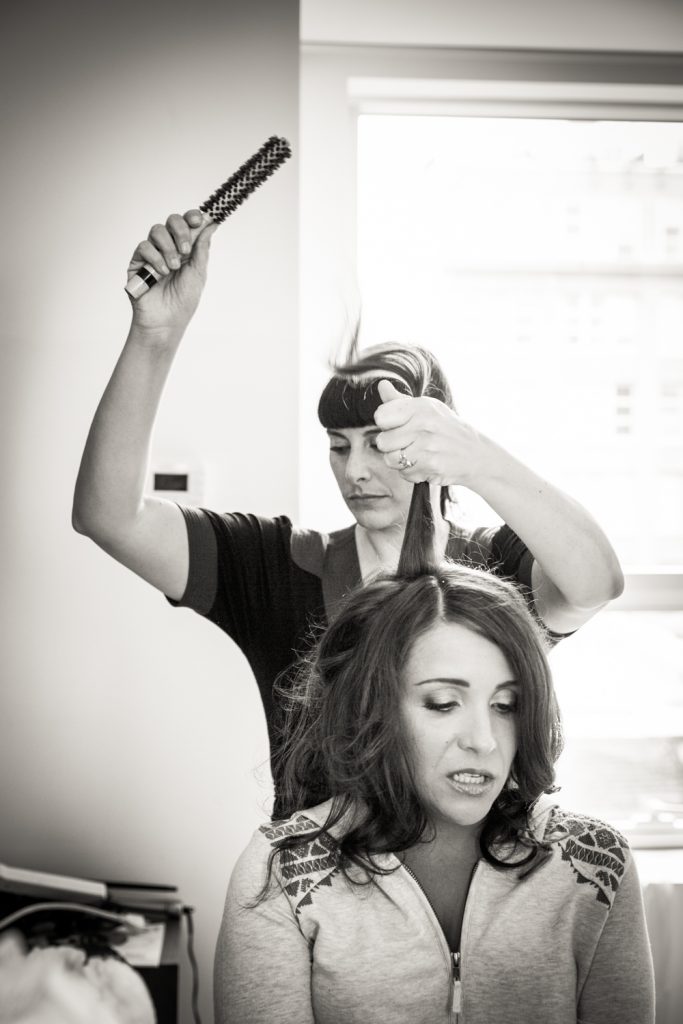 Black and white photo of bride having her hair fixed