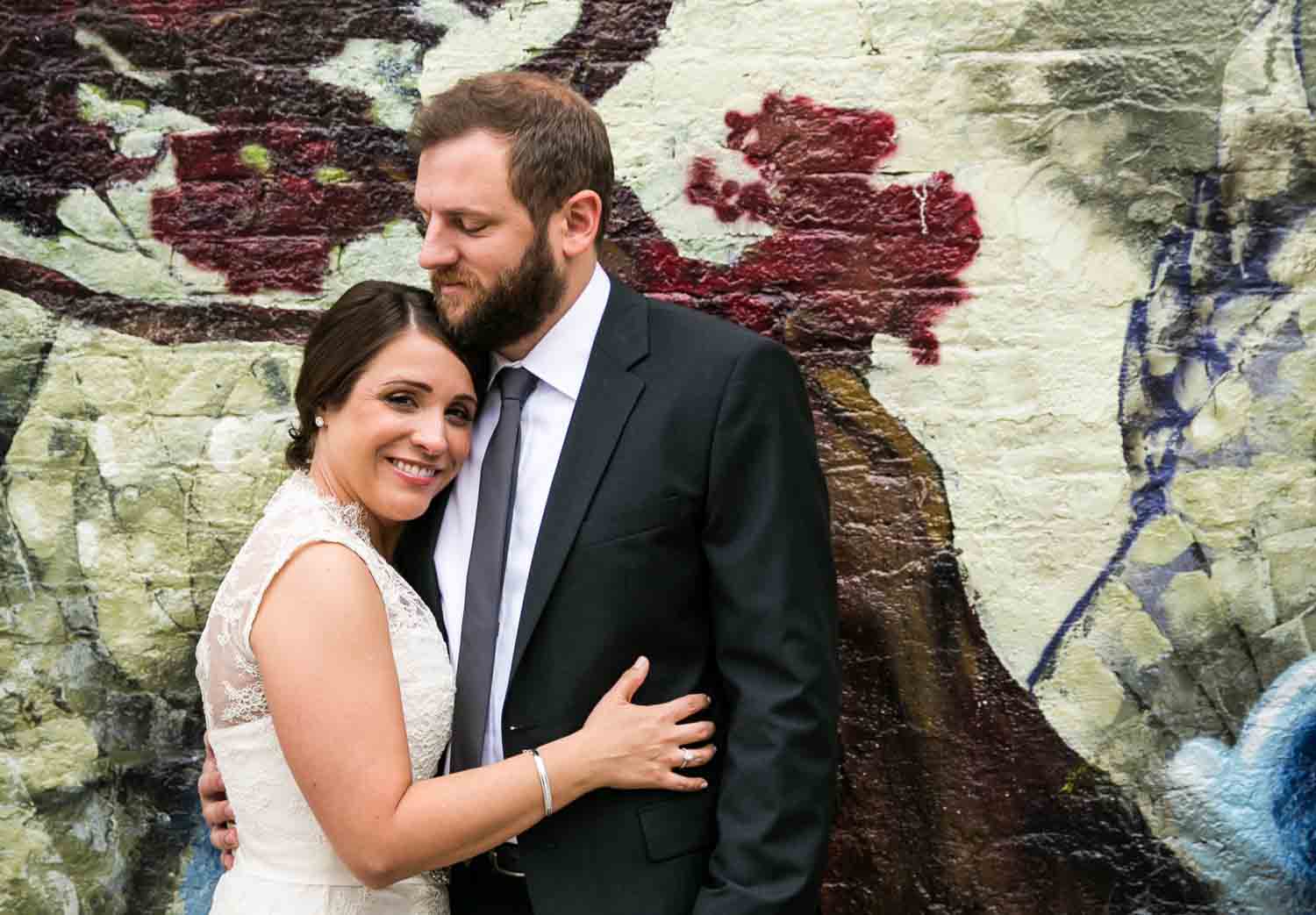 Portrait of bride and groom with colorful mural in background