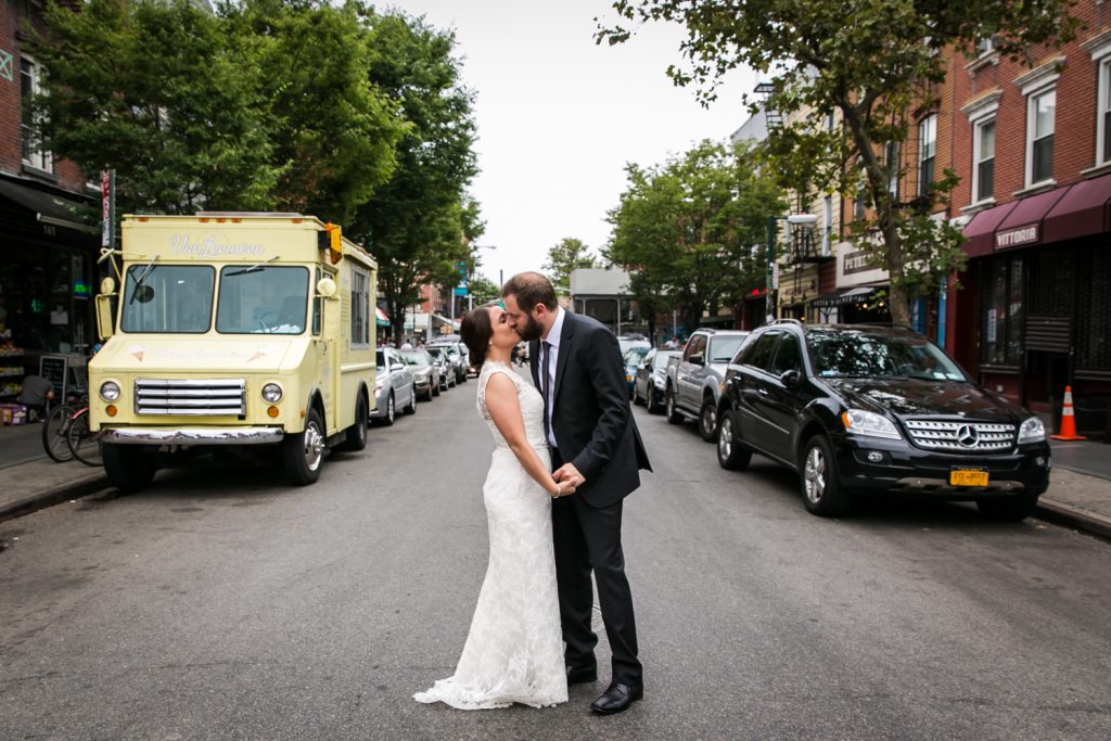 Bride and groom kissing in the middle of a street in Williamsburg