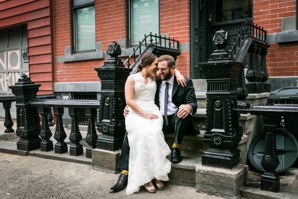 Bride sitting on groom's lap on brownstone staircase in Brooklyn