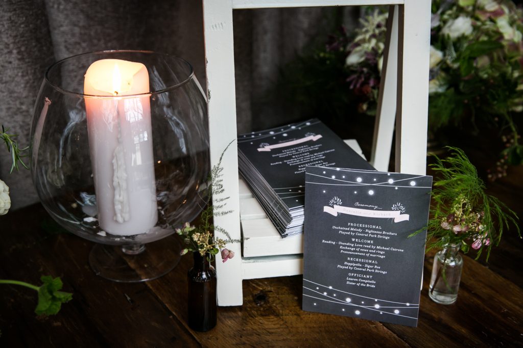 Wedding program and lit candle at a Brooklyn Winery wedding