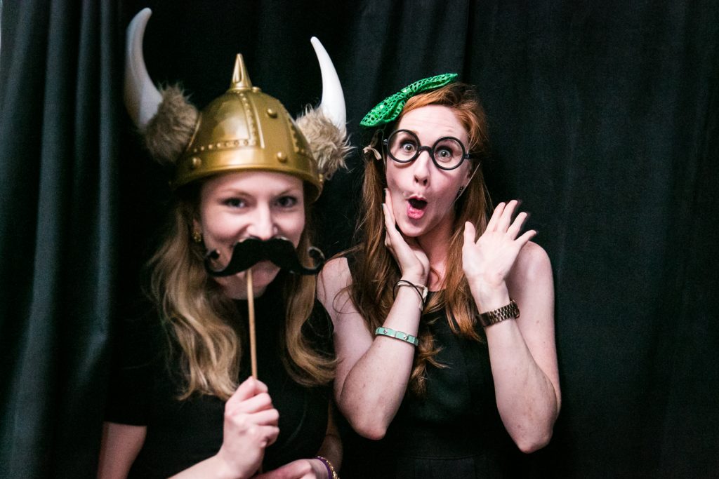 Two guests wearing props at a photobooth