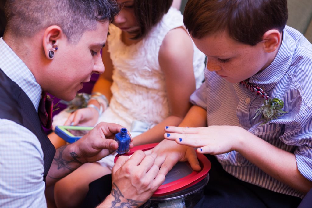 Groom painting boy's nails while waiting for a NYC LGBTQ City Hall wedding