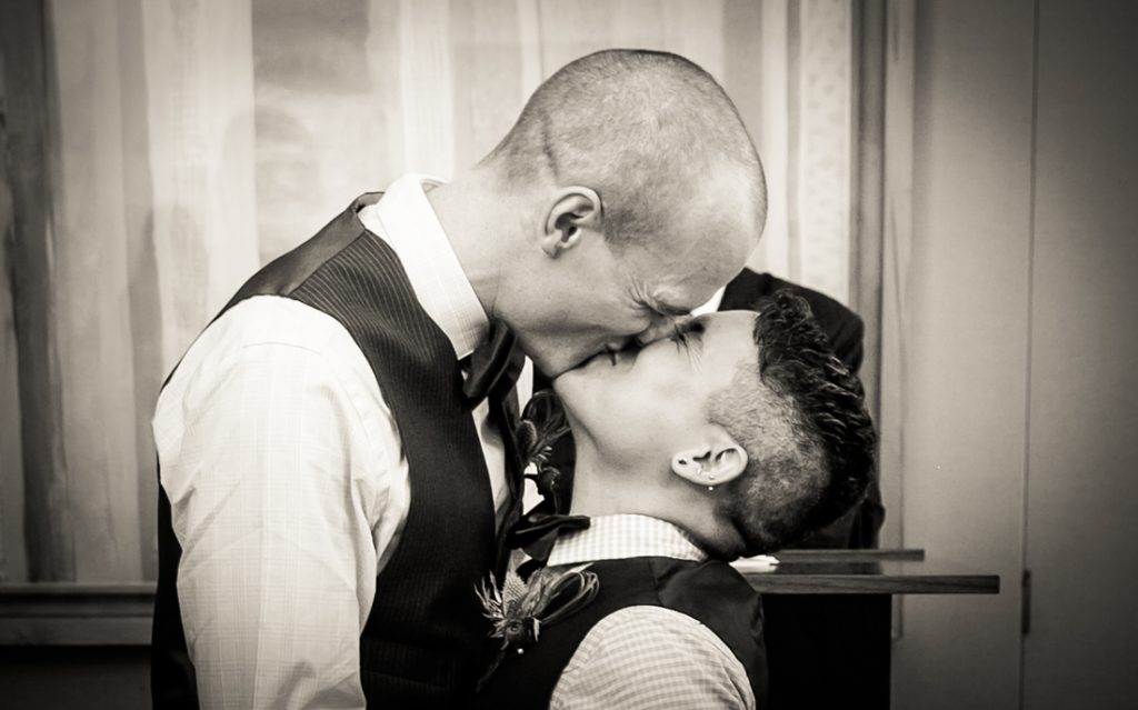 Black and white photo of two grooms kissing during a NYC LGBTQ City Hall wedding