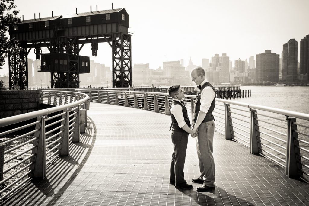 Black and white photo of two grooms holding hands at Gantry Plaza State Park