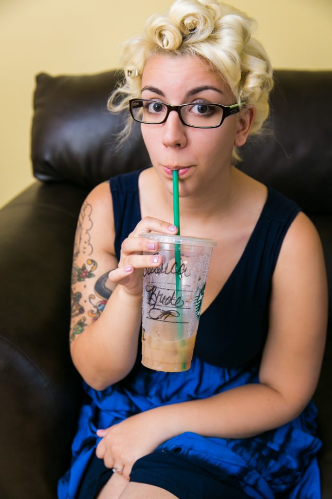 Bride sipping iced coffee before her Riviera Mansion Waterfront wedding