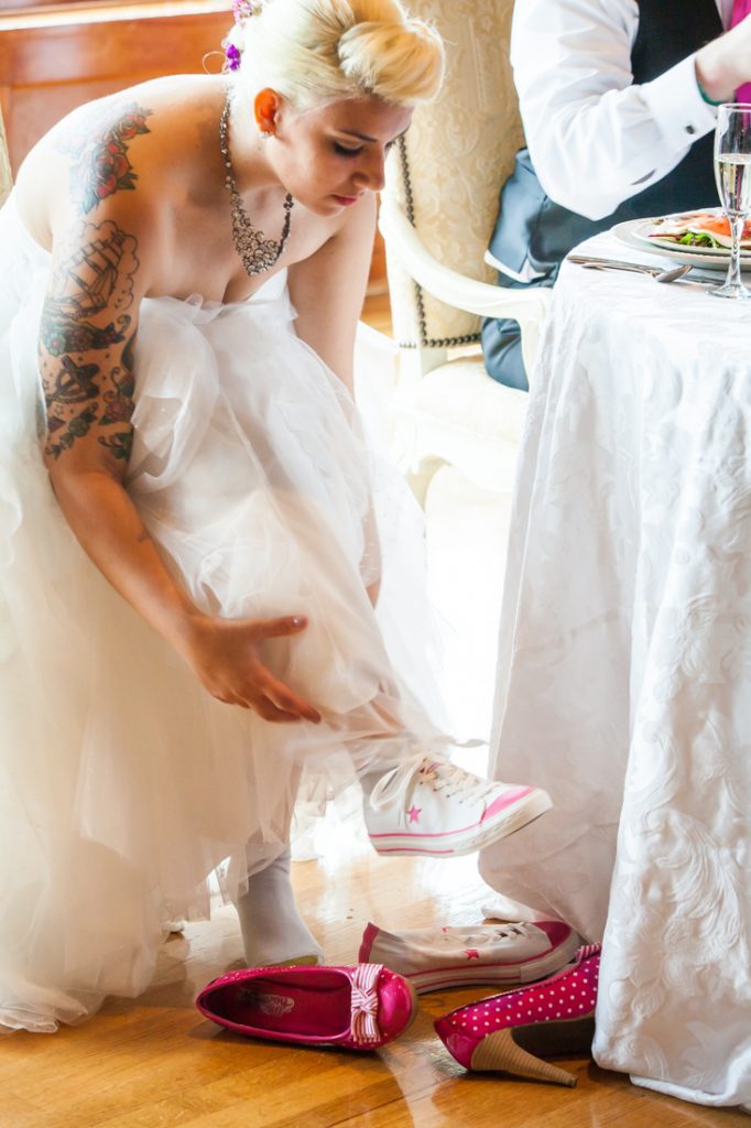 Bride changing shoes into Converse sneakers
