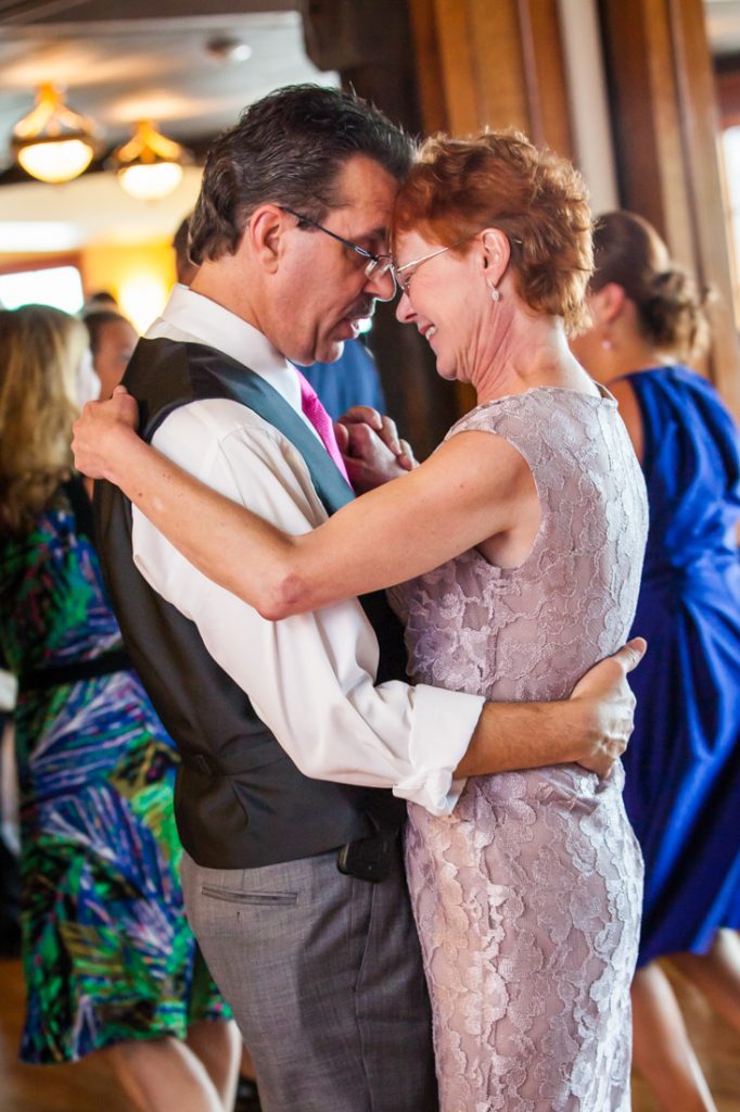 Parents of the bride dancing close during reception