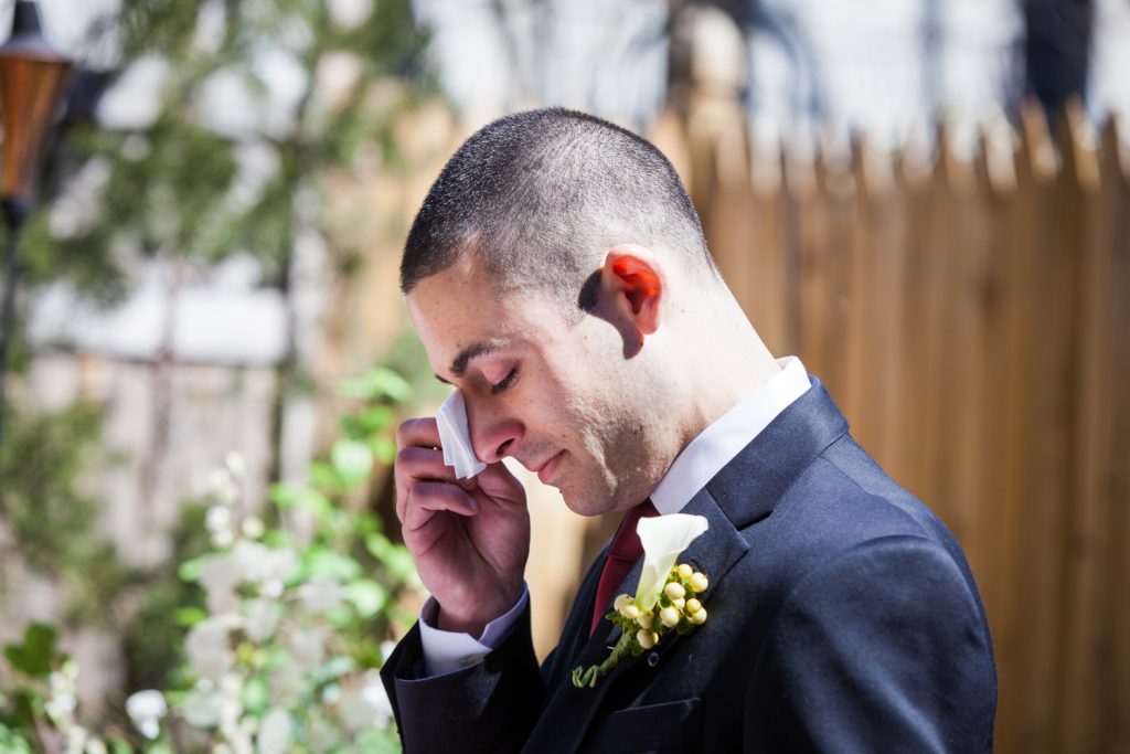Groom wiping away tear at Brooklyn backyard wedding ceremony