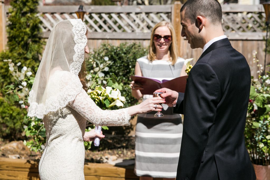 Bride sharing cup of wine with groom at Brooklyn backyard wedding ceremony