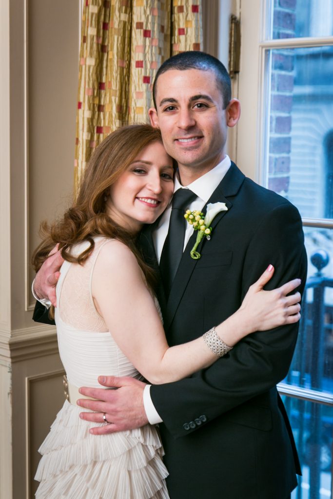 Harvard Club wedding photos of bride and groom hugging in front of window