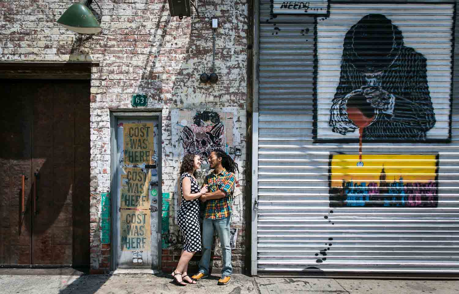 Meatpacking District engagement photos of couple dancing in front of graffiti wall