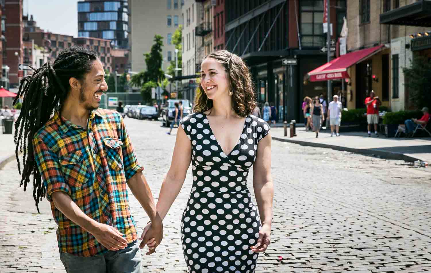 Couple walking hand-in-hand on cobblestone street