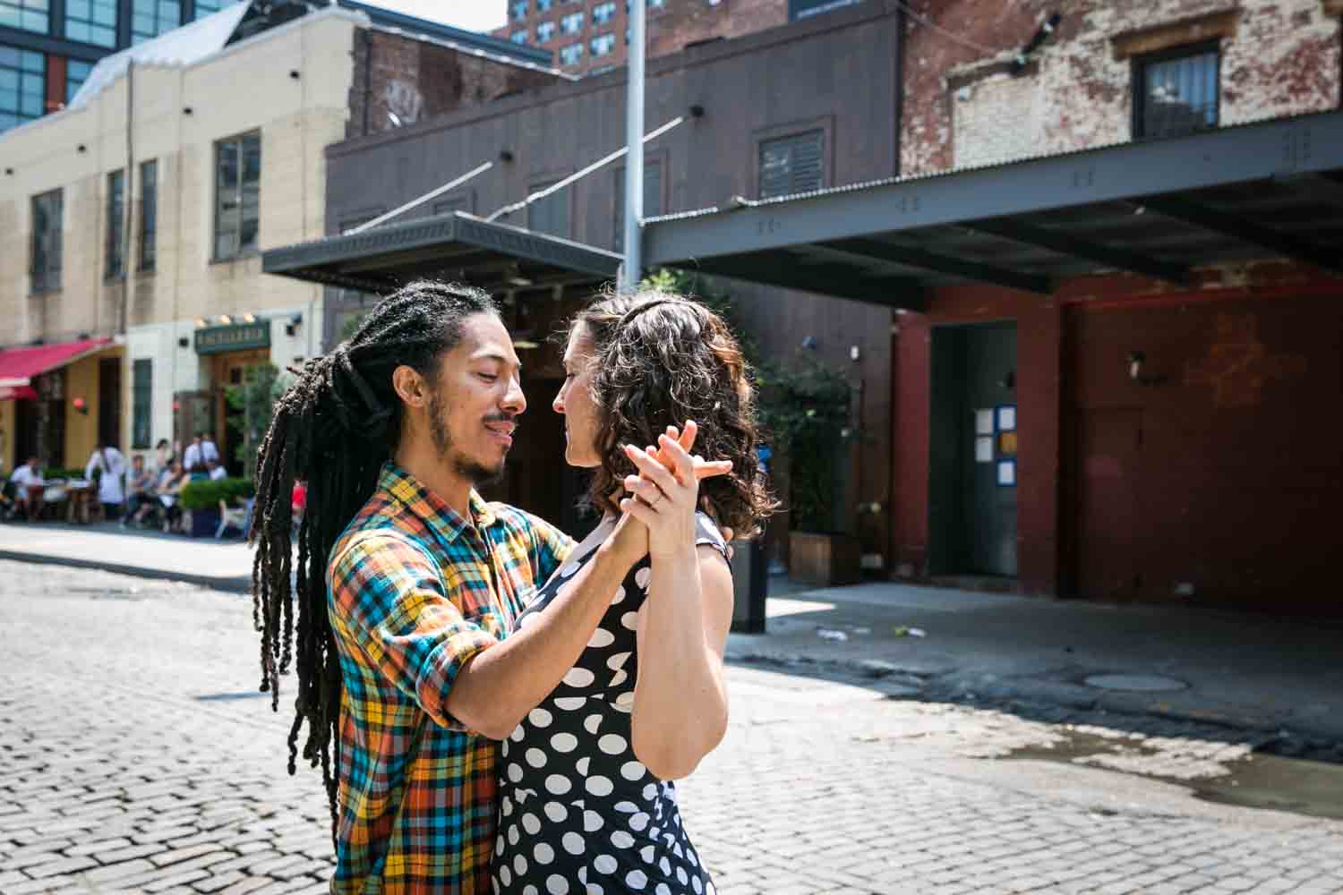 Meatpacking District engagement photos of couple dancing on cobblestone street