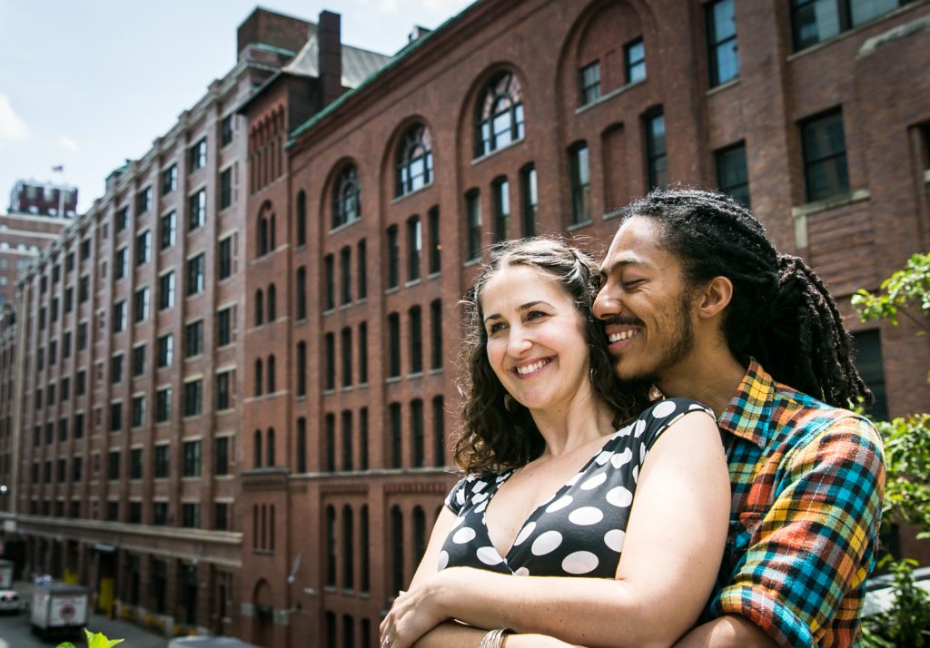 Meatpacking District engagement photos of couple hugging in front of warehouse building
