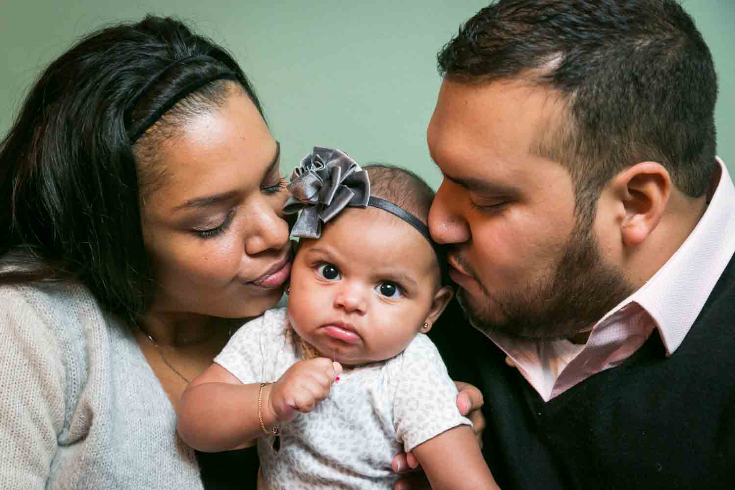 Prospect Park family portrait of parents kissing angry baby on both cheeks
