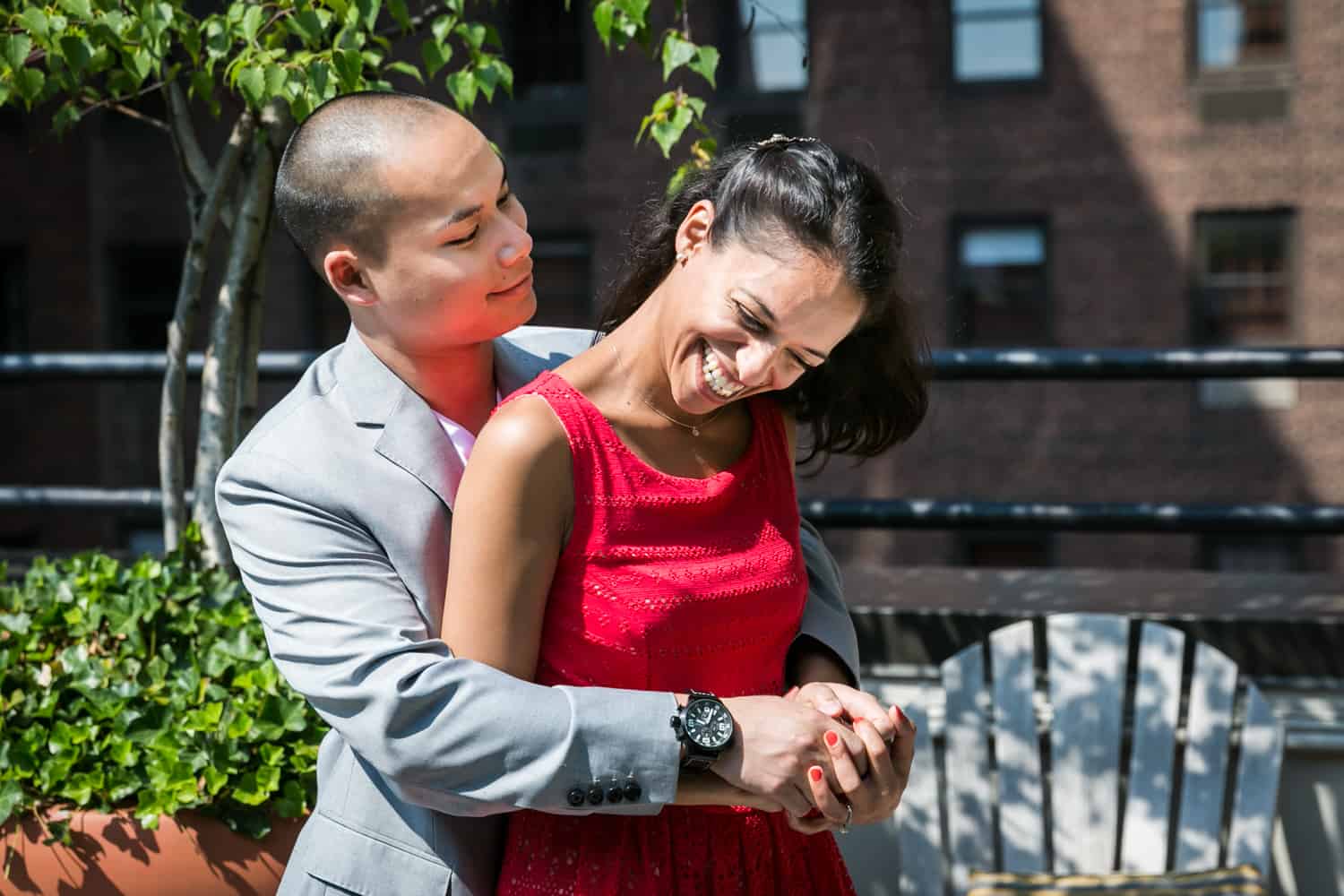 Couple laughing on roof terrace during a Hudson Hotel engagement shoot