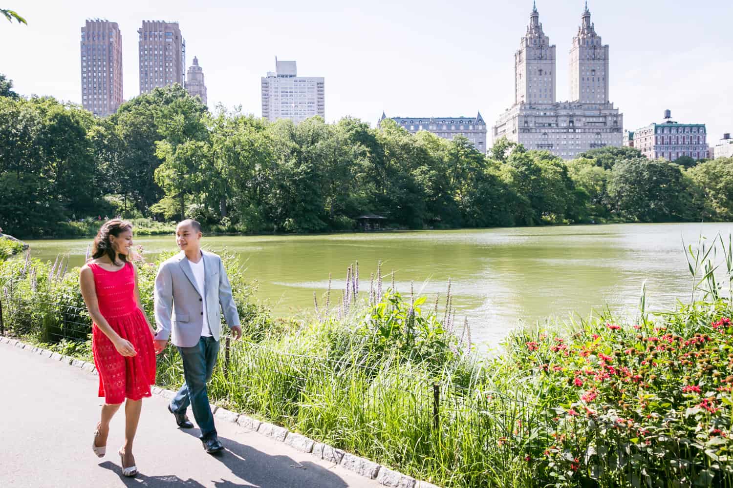 Couple walking beside Central Park lake