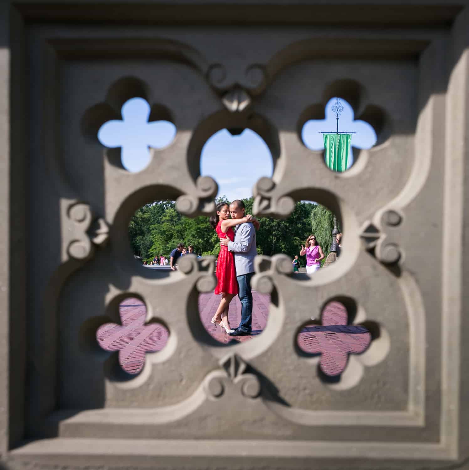 View through Bethesda Fountain fence of couple hugging