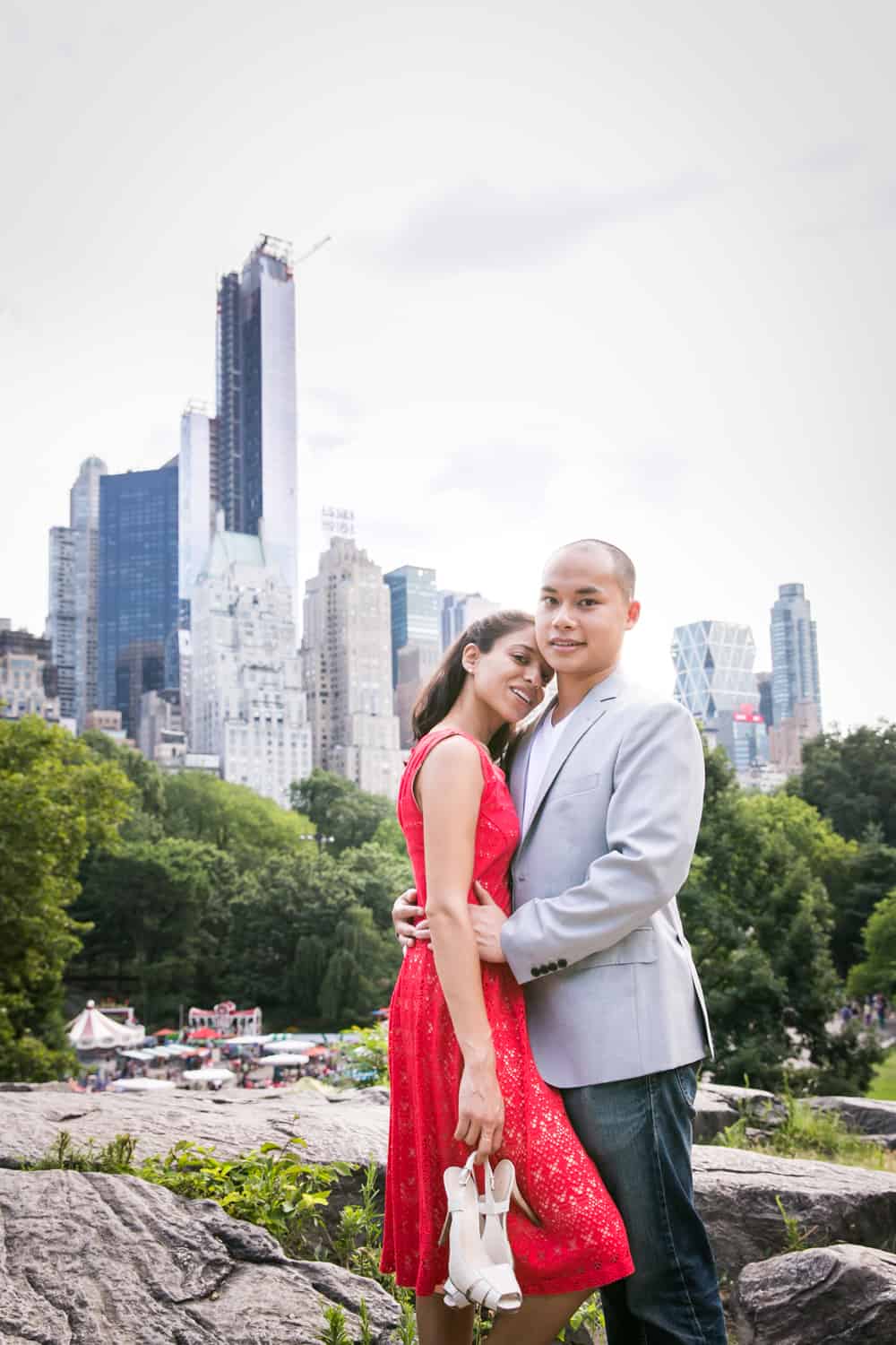 Couple on top of Umpire Hill in Central Park with NYC skyline in background
